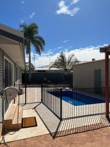 a fence in front of a swimming pool at Billfish in Exmouth +6 photos