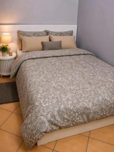 a bed with a gray comforter and pillows at اويسس Oasis in Jeddah