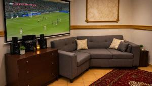 a living room with a couch and a large screen at اويسس Oasis in Jeddah
