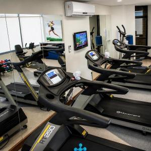 a gym with a bunch of treadmills in a room at Sol Alphaville Hotel By Your Alpha Stay 1602 in Barueri