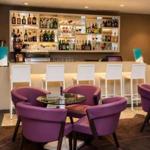 a restaurant with purple chairs and a table and a bar at Sol Alphaville Hotel By Your Alpha Stay 1602 in Barueri