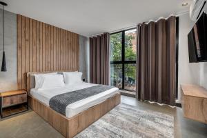 a bedroom with a bed and a large window at Apartamentos HOUSY Laureles in Medellín +28 photos