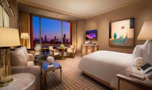 a hotel room with a bed and a living room at Wynn Macau in Macau