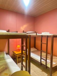 a room with three bunk beds and a table with a lamp at SunriseStay in Panglao Island
