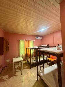 a room with two beds and a room with tables and chairs at SunriseStay in Panglao Island