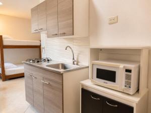 a kitchen with a sink and a microwave at Hotel Laureles Palo Alto in Medellín
