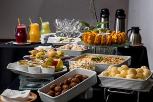 a table topped with plates of food and drinks at Quality Hotel Curitiba in Curitiba