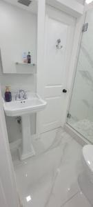 a white bathroom with a sink and a shower at Hard Rock Area Modern Studio in Miami Gardens