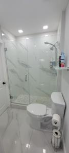 a white bathroom with a toilet and a shower at Hard Rock Area Modern Studio in Miami Gardens