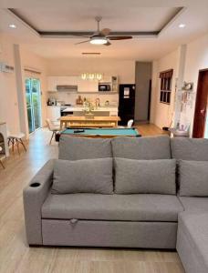 a living room with a couch and a pool table at Banrao Pool Villa Khaoyai บ้านเราพูลวิลล่าเขาใหญ่ in Ban Tha Maprang