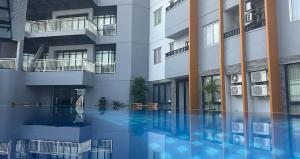 a large building with a swimming pool in front of it at Twin Tower Hotel & Residence in Surabaya