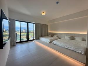a bedroom with two beds and a large window at wangderfu享富Villa in Dongshan