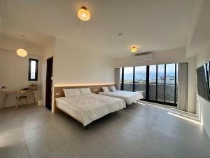 a bedroom with two beds and a large window at wangderfu享富Villa in Dongshan