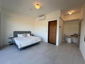 a bedroom with a bed and a desk and a door at wangderfu享富Villa in Dongshan