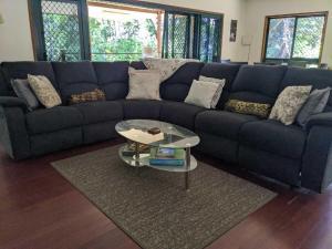 a blue couch in a living room with a table at Daintree Private Escape in Cow Bay