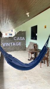 a hammock in a room with a casa village sign at Pousada Mar Vintage in Laguna