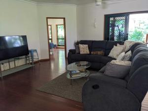 a living room with a couch and a tv at Daintree Private Escape in Cow Bay