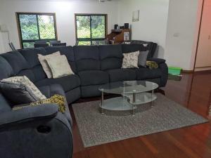a living room with a blue couch and a table at Daintree Private Escape in Cow Bay +43 photos