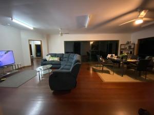a living room with a couch and a dining room at Daintree Private Escape in Cow Bay