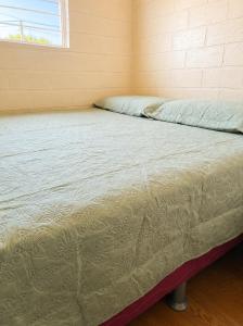 an empty bed in a room with a window at Aconchego in Fortaleza