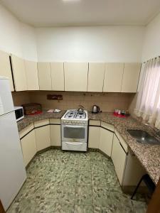 a small kitchen with a stove and a sink at Espacio Patagonico in Comodoro Rivadavia