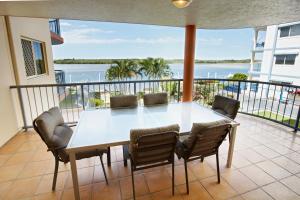 a table and chairs on a balcony with a view of the water at On The River Apartments in Maroochydore