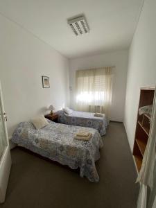 a bedroom with two beds and a window with curtains at Espacio Patagonico in Comodoro Rivadavia