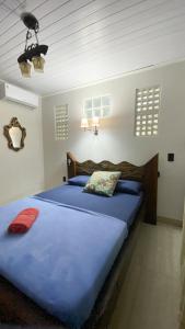 a bedroom with a large blue bed in a room at Pousada Mar Vintage in Laguna