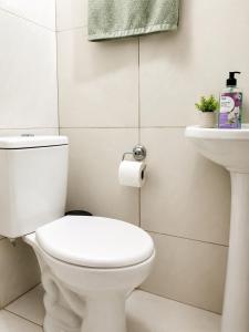 a bathroom with a white toilet and a sink at Aconchego in Fortaleza