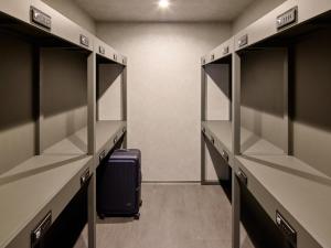 an empty locker room with a suitcase in the middle at Minn Hakata Station East in Sumiyoshi +7 photos