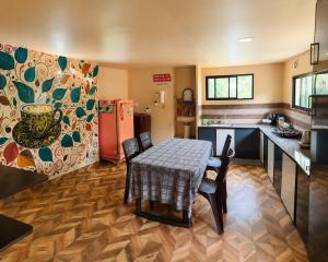 a kitchen with a table with chairs and a refrigerator at Sahyadri Homestay wayanad in Kalpetta