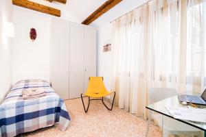 a bedroom with a yellow chair and a desk at Cà Boldo Terrace 2.0 in Venice