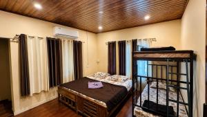 a room with two bunk beds and a bed with a desk at Sahyadri Homestay wayanad in Kalpetta