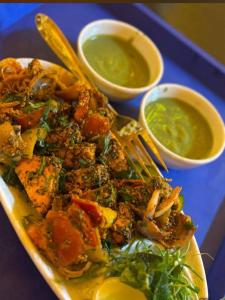 a plate of food with meat and vegetables and sauce at Hotel soni plaza in Jhālrapātan