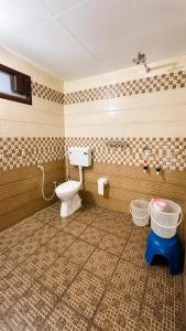 a bathroom with a toilet and two buckets at Sahyadri Homestay wayanad in Kalpetta