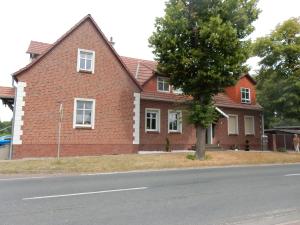 ハーフェルベルクにあるFerienwohnung Czampielの通りの前に木のあるレンガ造りの家