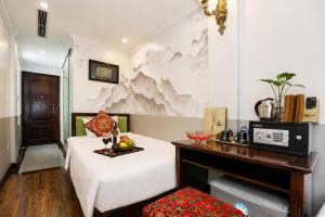 a room with a bed and a table with food on it at Golden Sail Hotel & Travel in Hanoi