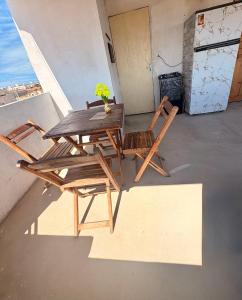a wooden table and chairs sitting on a balcony at Por do sol residence in Aracati