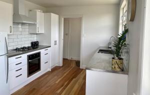 a kitchen with white cabinets and a counter top at Dublin No 5 in Martinborough +6 photos