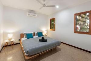a bedroom with a large bed with blue pillows at Kingfisher in Exmouth +18 photos