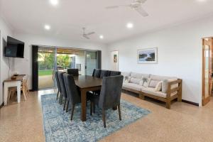 a dining room with a table and a couch at Kingfisher in Exmouth