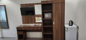 a room with a desk with a television and a refrigerator at فندق دار المتكاملة 4 in Al Khansāk
