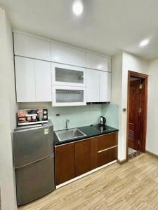 a kitchen with a sink and a dishwasher at Eco Nest Residence in Hanoi +4 photos