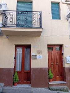 a building with two doors and a balcony at Elico Di Sicilia home B in Sambuca di Sicilia