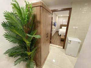 a palm plant in a room with a bedroom at راكة سويت الخبر للشقق الفندقية المخدومة in Al Khobar