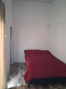 a red bed sitting in a white room at Apto centrico in Dolores +2 photos