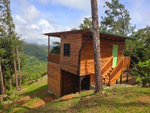 a wooden cabin with a deck in the woods at Altos del Dragón in Valle de Anton