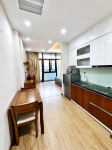 a kitchen with white cabinets and a wooden floor at Eco Nest Residence in Hanoi