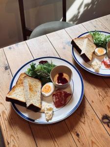 two plates of toast and eggs on a wooden table at MU HEN KO Tokyo in Tokyo +44 photos