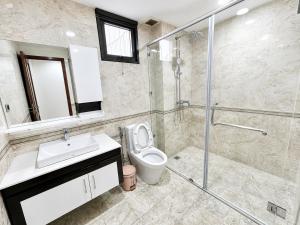 a bathroom with a shower and a toilet and a sink at Eco Nest Residence in Hanoi